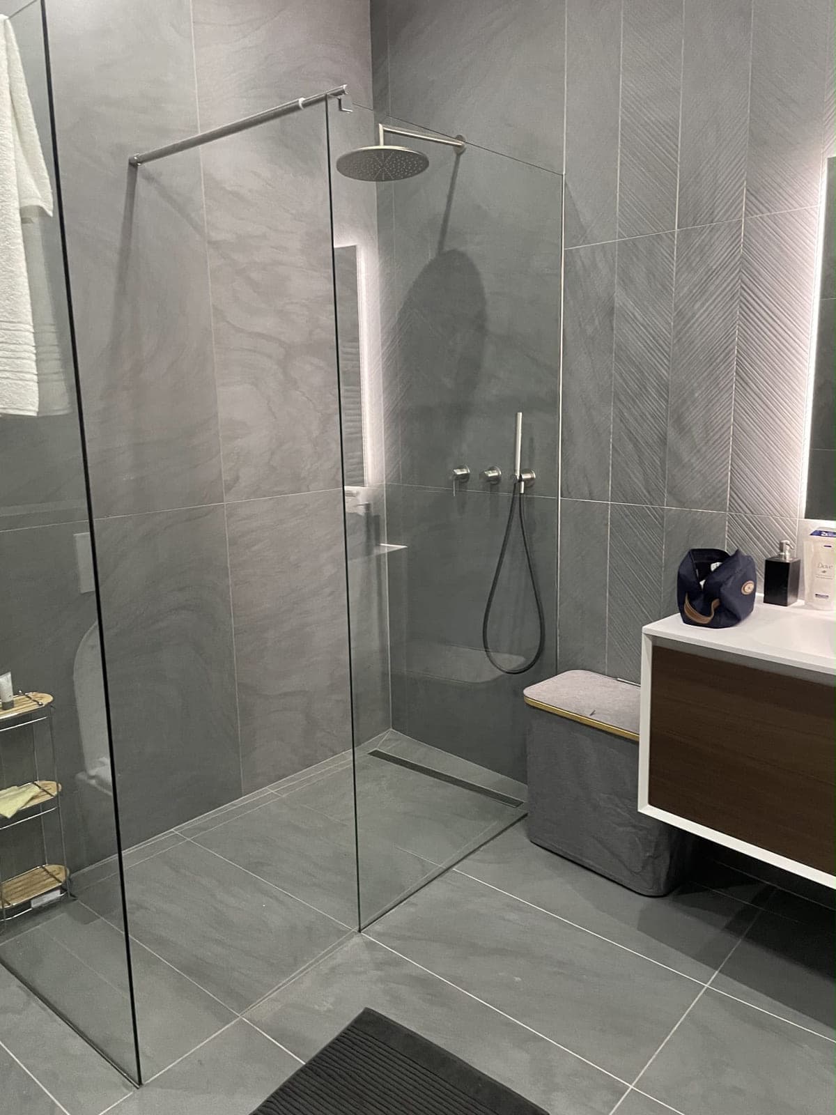 Douche à l'italienne avec paroi fixe en verre et meuble vasque suspendu, carrelage gris grand format