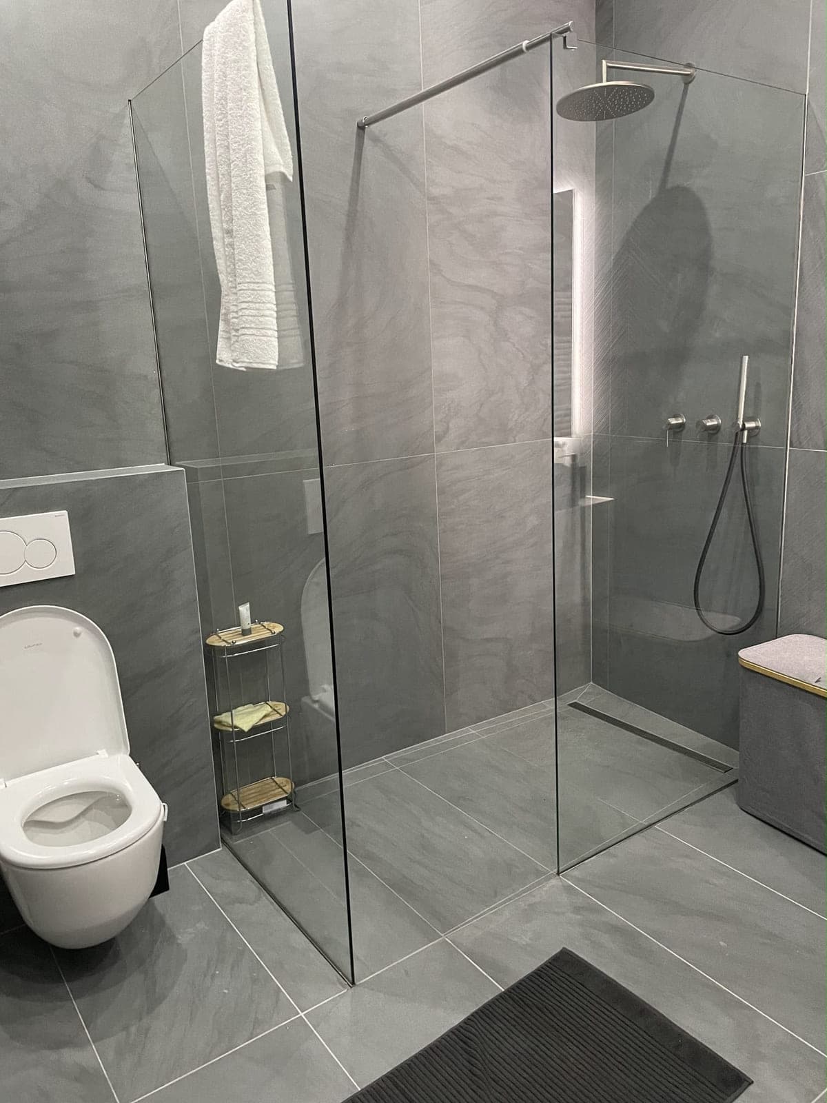 WC suspendu et douche à l'italienne avec caniveau encastré et robinetterie inox brossé