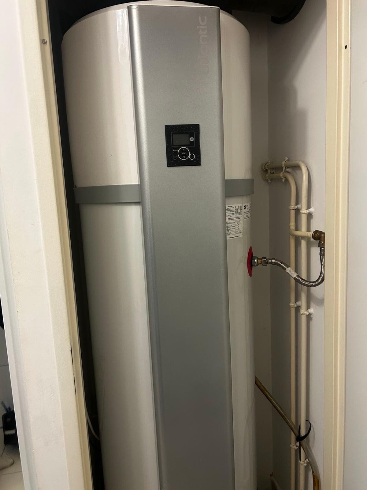 Chauffe-eau thermodynamique installé dans un placard technique avec ses raccordements