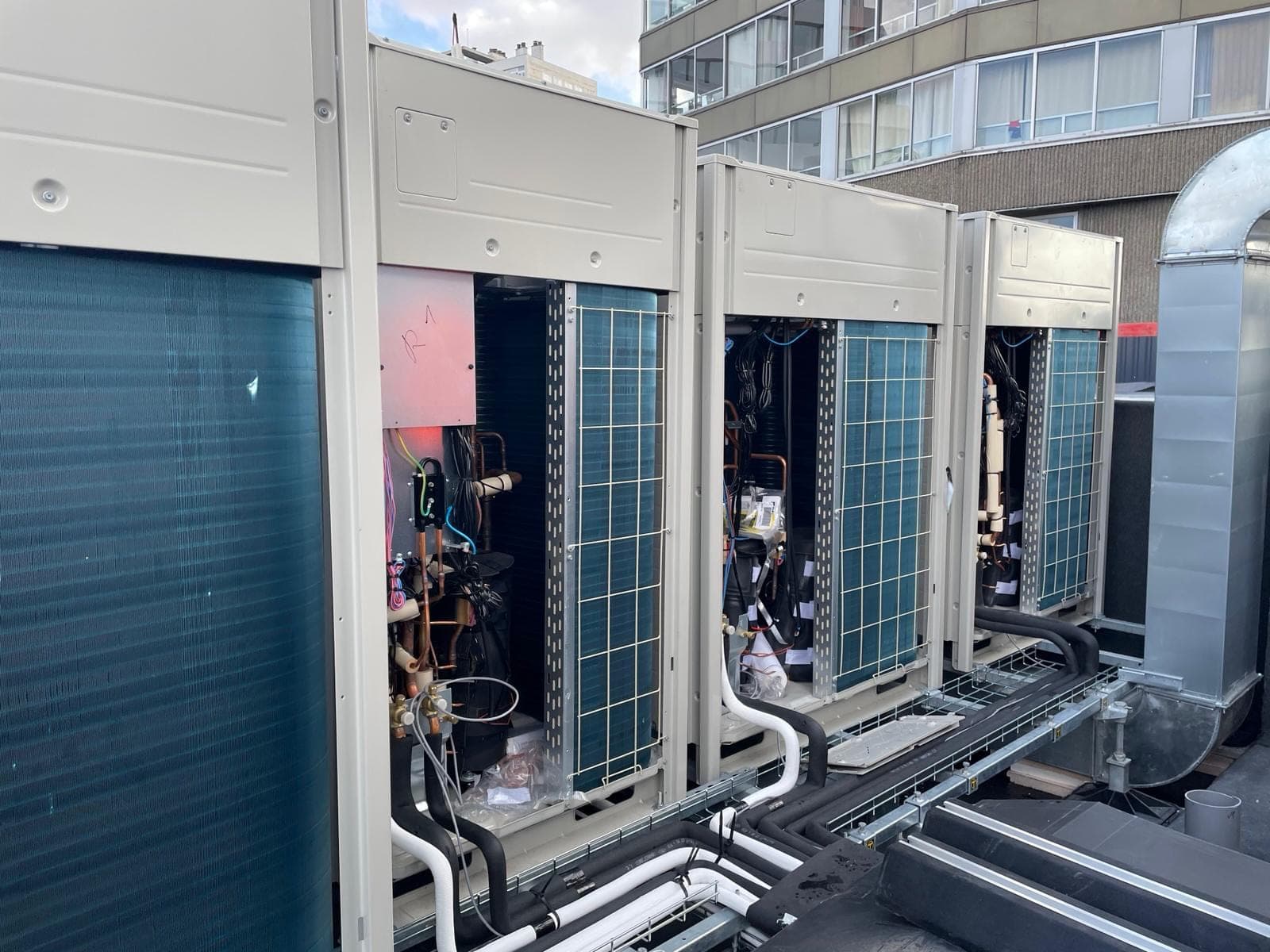 Groupes extérieurs de climatisation alignés en toiture, liaisons frigorifiques sur chemin de câbles, installés par HYDROBAT SOLUTIONS